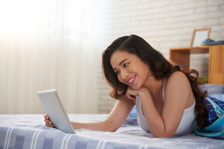A woman smiling on her labtop.